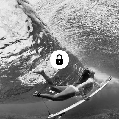 Brisa Hennessy duck diving under a wave with lock icon overlay