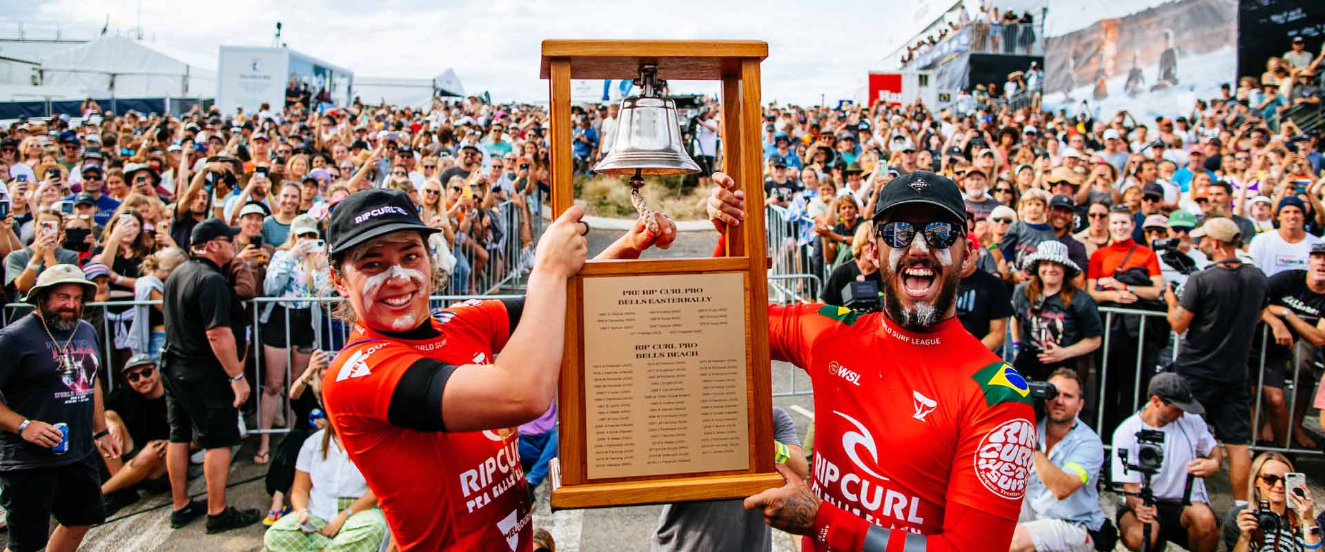 Bells beach winners hold the bell up in front of a cheering crowd